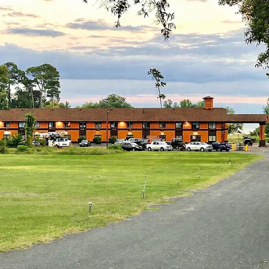 Toledo Bend Inn, two-story lakeside inn at dusk with pines